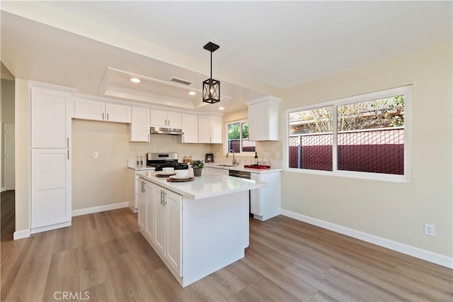 kitchen with pendant lighting, light wood-type flooring, white cabinetry, and stainless steel range with gas stovetop