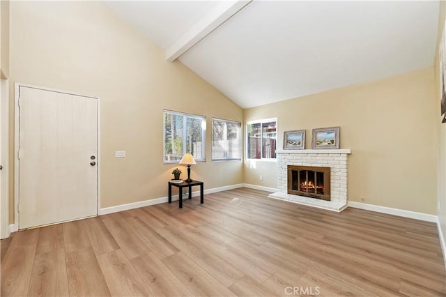 unfurnished living room with beam ceiling, light wood-type flooring, and a brick fireplace