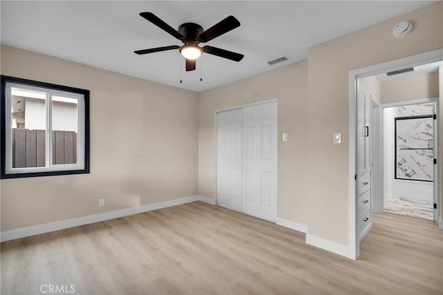 unfurnished bedroom with ceiling fan, light wood-type flooring, and a closet