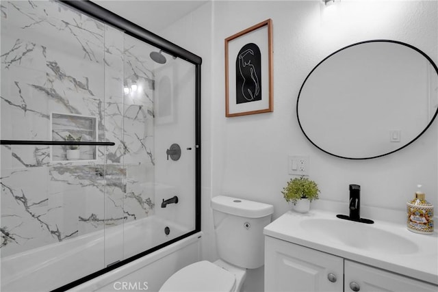 full bathroom featuring combined bath / shower with glass door, vanity, and toilet