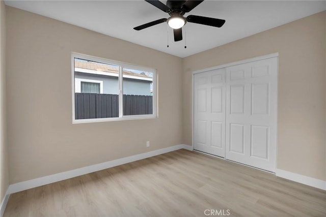 unfurnished bedroom featuring ceiling fan, a closet, and light hardwood / wood-style floors