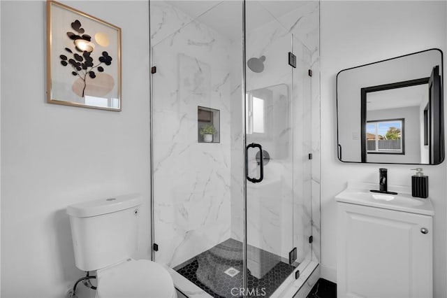 bathroom featuring toilet, a shower with door, and vanity