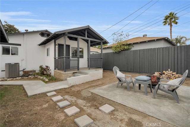 exterior space featuring cooling unit, a porch, and a fire pit