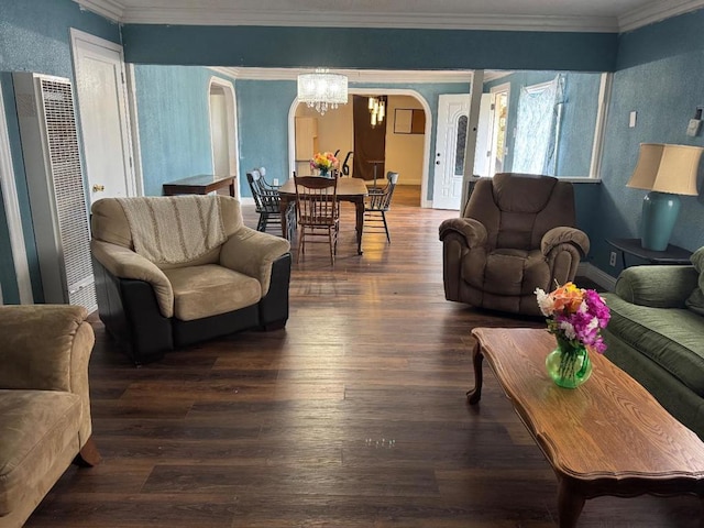 living room featuring crown molding, dark hardwood / wood-style flooring, and an inviting chandelier