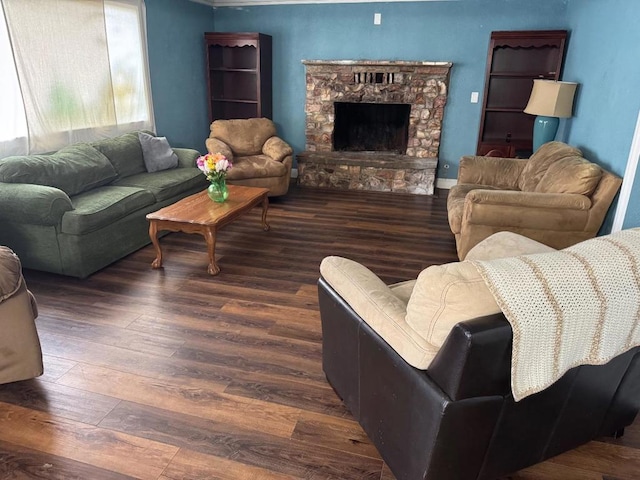 living room with a stone fireplace and dark hardwood / wood-style flooring