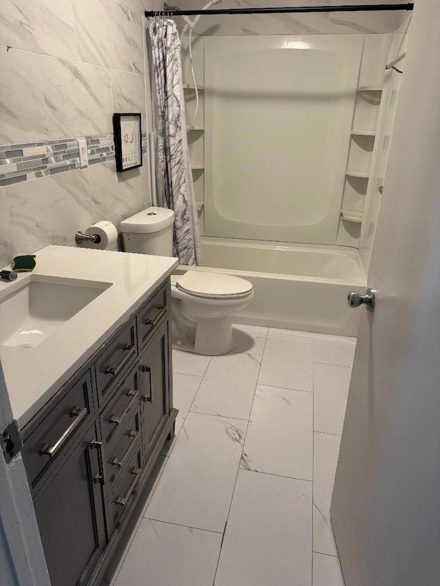 full bathroom featuring toilet, vanity, tile walls, and shower / bath combo