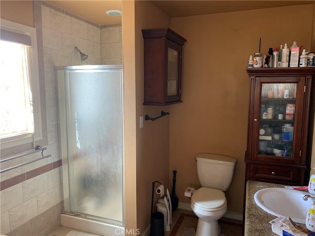 bathroom featuring vanity, toilet, and an enclosed shower