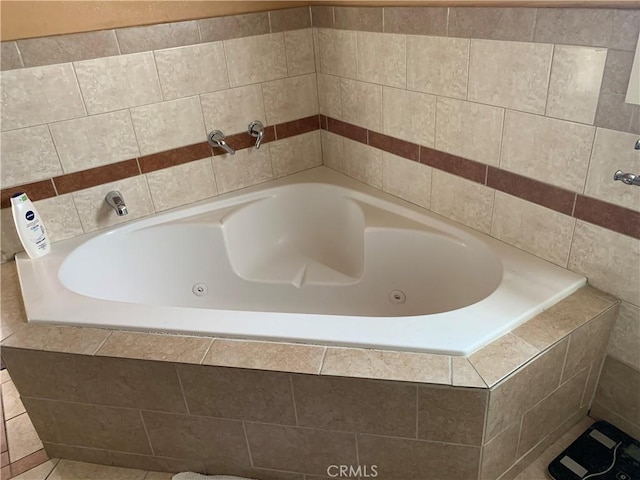 bathroom featuring tile patterned flooring and a relaxing tiled tub