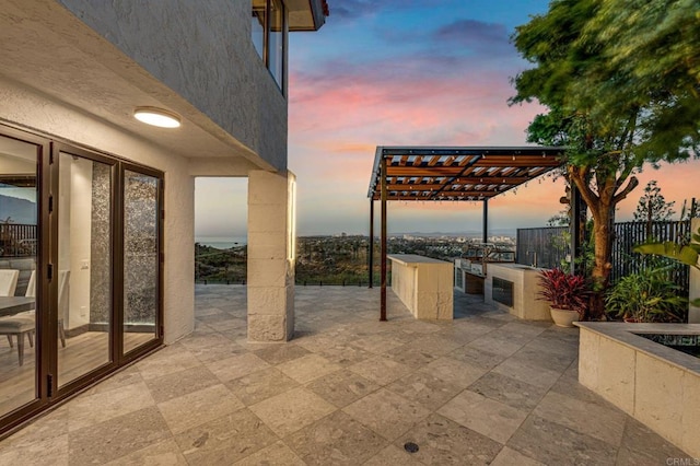 patio terrace at dusk featuring a pergola