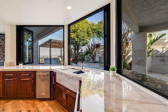 kitchen with sink, expansive windows, and light hardwood / wood-style floors