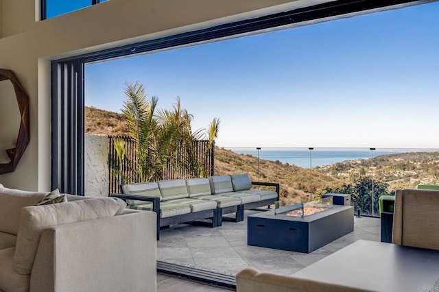 view of patio featuring a water view and an outdoor living space with a fire pit