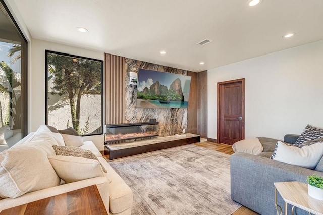 living room featuring light hardwood / wood-style flooring and a stone fireplace