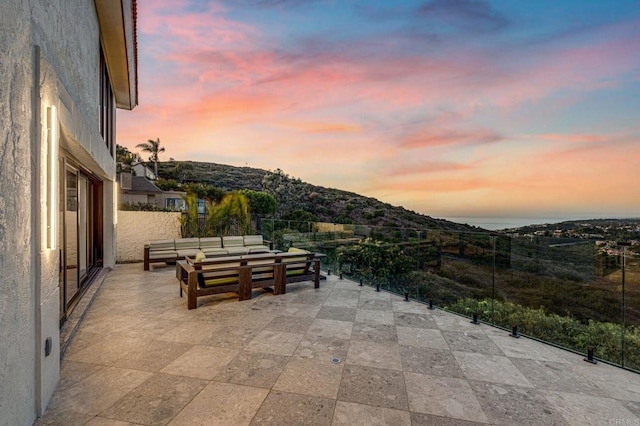 patio terrace at dusk featuring an outdoor living space and a mountain view