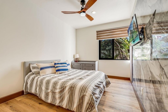 bedroom with ceiling fan and light hardwood / wood-style flooring