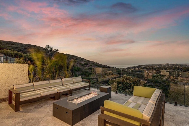 patio terrace at dusk with a mountain view and an outdoor living space with a fire pit