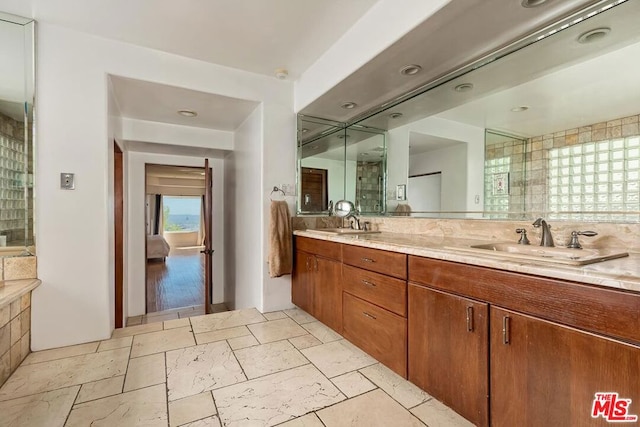 bathroom with a shower with shower door and vanity