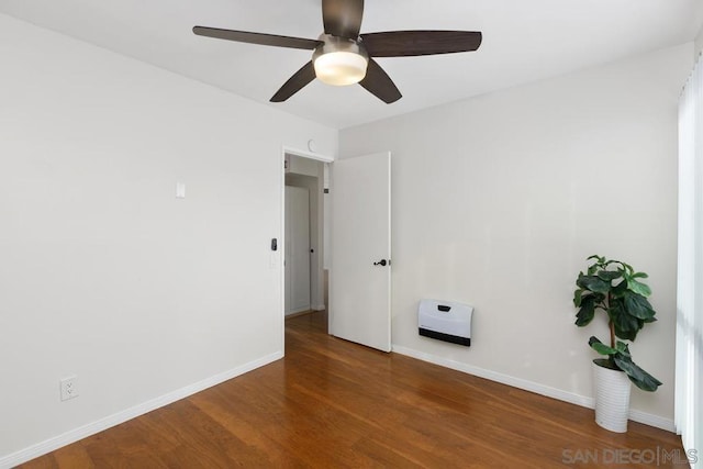 spare room with dark wood-type flooring and ceiling fan