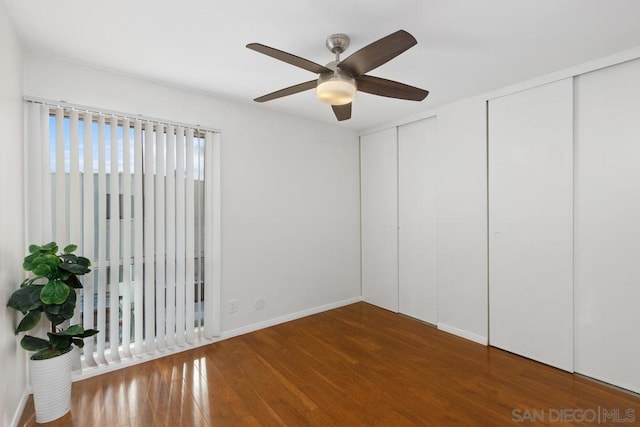 unfurnished bedroom featuring ceiling fan, two closets, and dark hardwood / wood-style floors