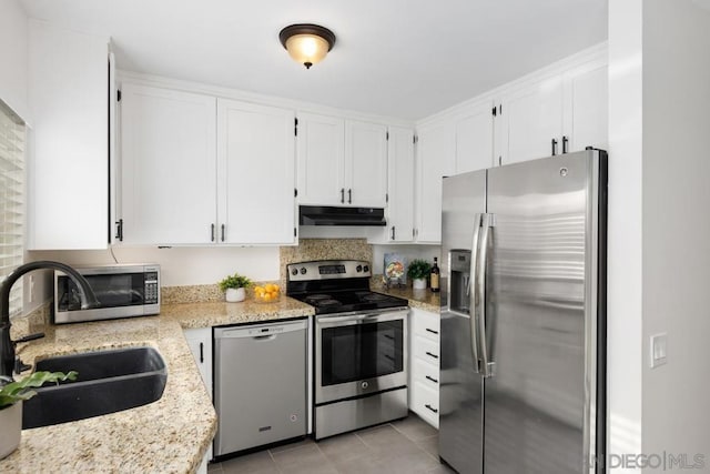 kitchen featuring sink, light stone counters, stainless steel appliances, and white cabinetry