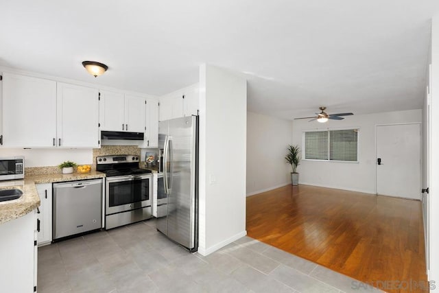 kitchen featuring ceiling fan, white cabinets, light stone countertops, and stainless steel appliances