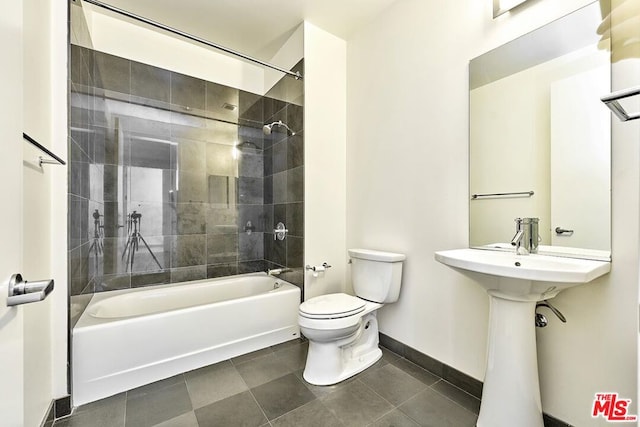 bathroom featuring toilet and tiled shower / bath