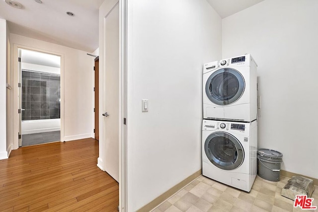 laundry area featuring light hardwood / wood-style flooring and stacked washer and clothes dryer