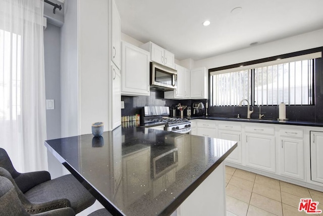 kitchen featuring backsplash, sink, white cabinets, and stainless steel appliances