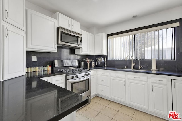 kitchen featuring white cabinets, appliances with stainless steel finishes, backsplash, and sink