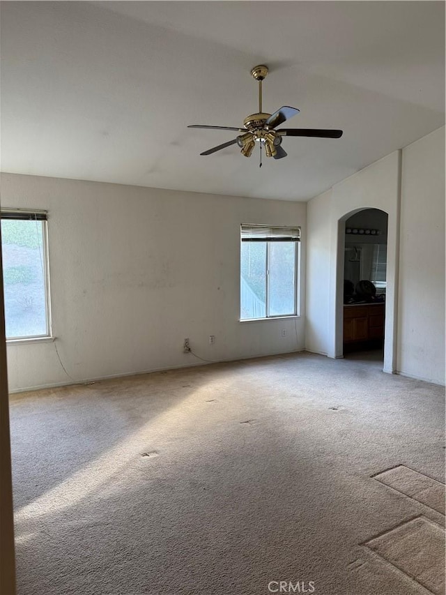 carpeted spare room featuring ceiling fan