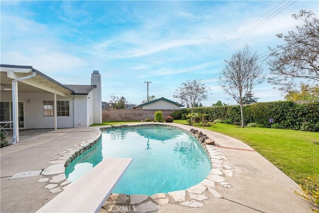 view of pool featuring a lawn, a diving board, and a patio