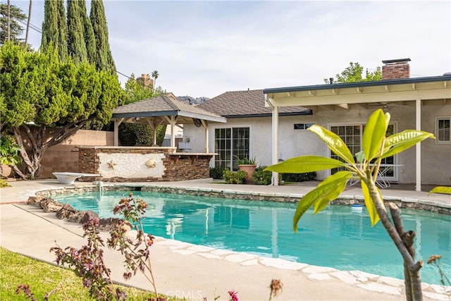 view of pool with ceiling fan, an outdoor bar, and a patio