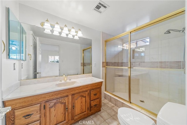 bathroom with tile patterned floors, vanity, an enclosed shower, and toilet