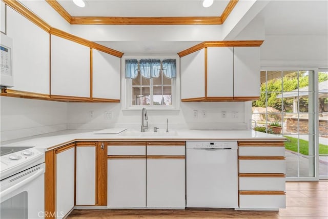 kitchen with white cabinets, white appliances, a healthy amount of sunlight, and sink