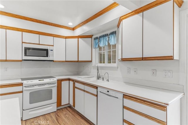 kitchen featuring sink, white cabinets, and white appliances