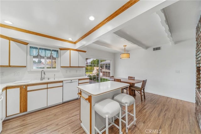 kitchen with hanging light fixtures, a kitchen island, white dishwasher, light hardwood / wood-style floors, and white cabinets