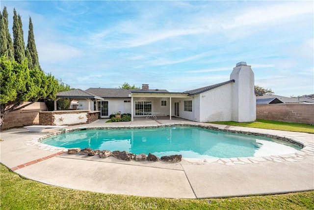 view of swimming pool with a diving board and a patio area