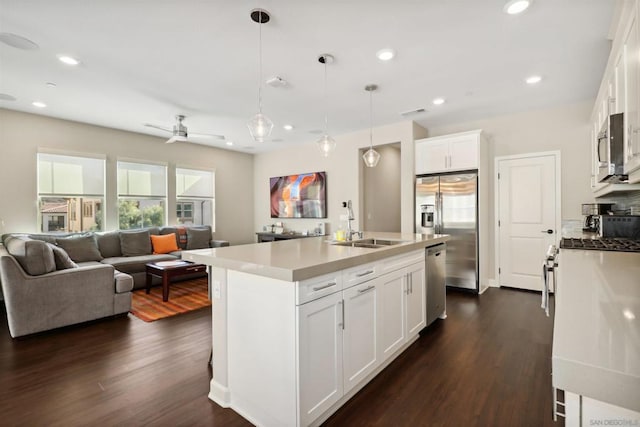 kitchen with a kitchen island with sink, white cabinets, hanging light fixtures, ceiling fan, and appliances with stainless steel finishes