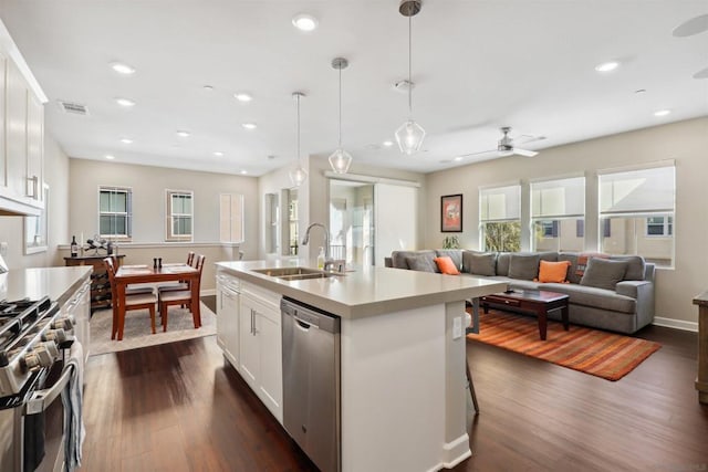 kitchen featuring white cabinetry, a kitchen island with sink, sink, and appliances with stainless steel finishes