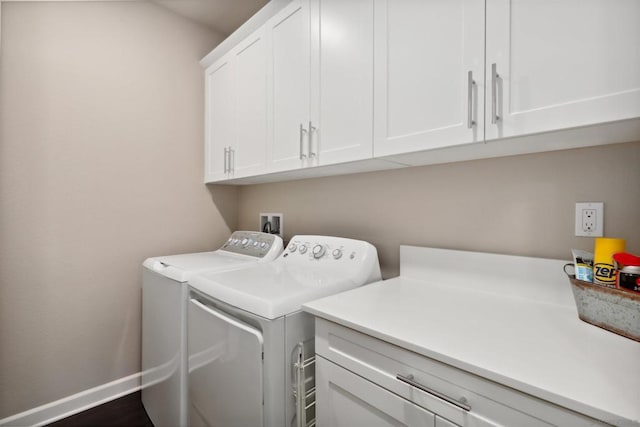 clothes washing area featuring cabinets and separate washer and dryer