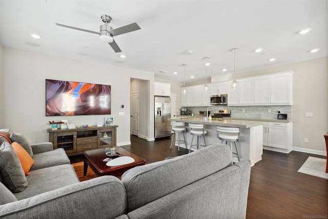 living room with dark hardwood / wood-style floors, ceiling fan, and sink