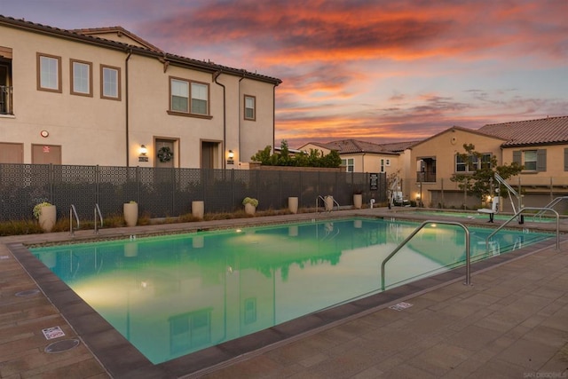 pool at dusk with a patio