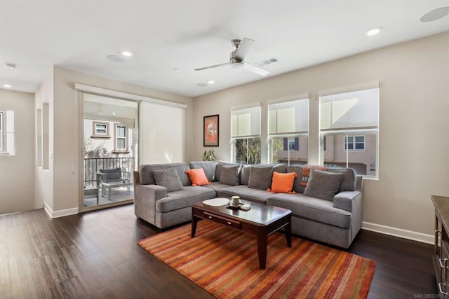 living room featuring ceiling fan, a healthy amount of sunlight, and dark hardwood / wood-style flooring