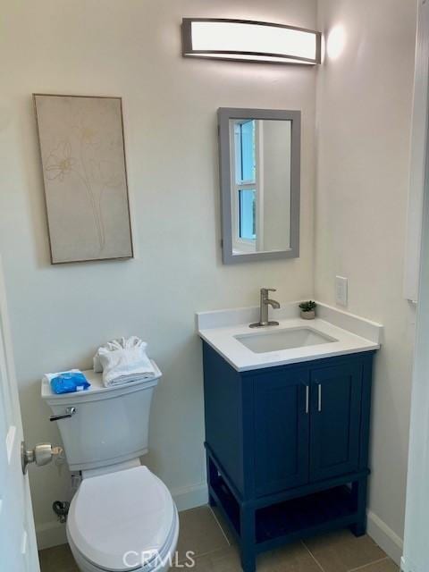 bathroom with tile patterned flooring, vanity, and toilet