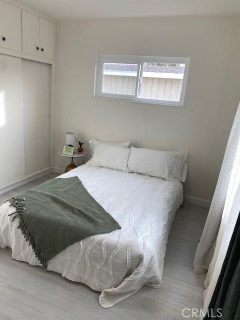 bedroom featuring multiple windows and light hardwood / wood-style floors