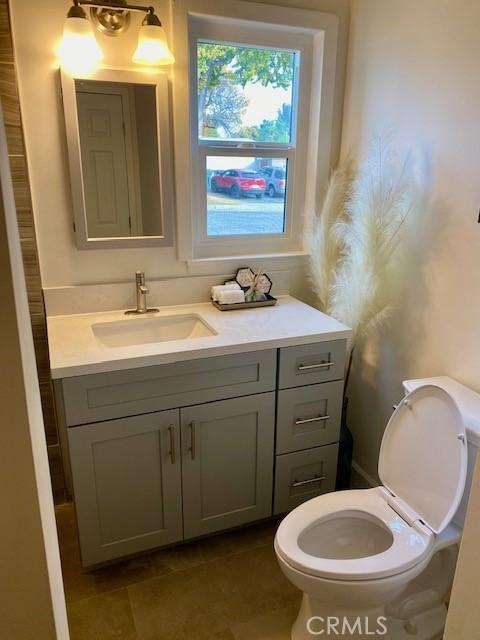 bathroom with tile patterned flooring, vanity, and toilet