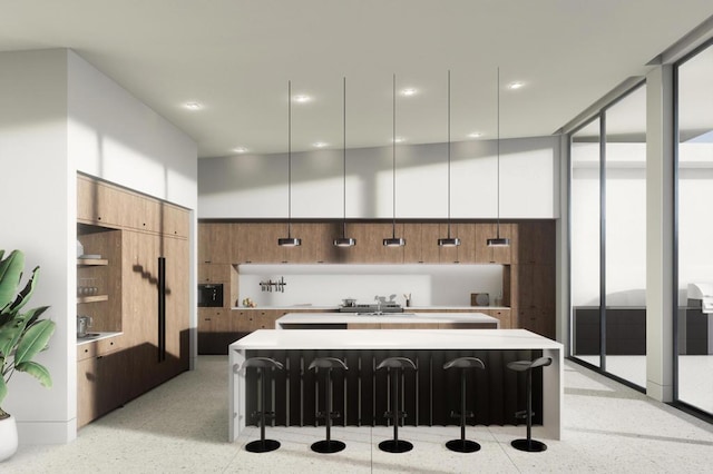 kitchen featuring a towering ceiling, a breakfast bar area, floor to ceiling windows, and a spacious island