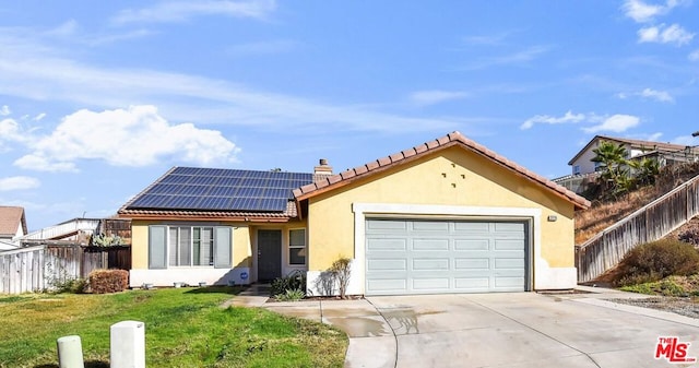 view of front of house featuring a garage, a front yard, and solar panels