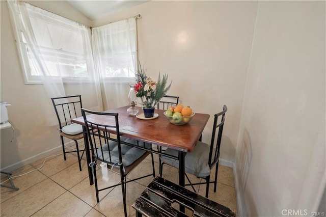 tiled dining room featuring lofted ceiling