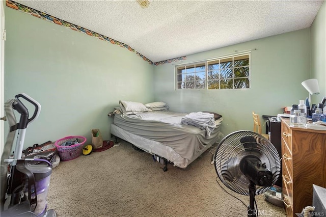 bedroom with lofted ceiling, carpet floors, and a textured ceiling