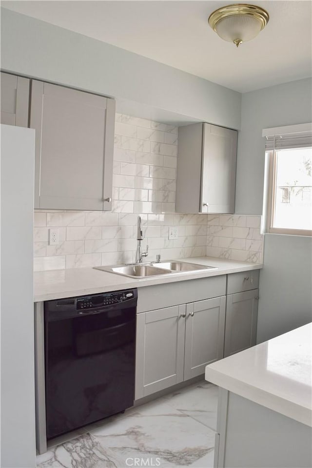 kitchen with gray cabinetry, decorative backsplash, dishwasher, and sink